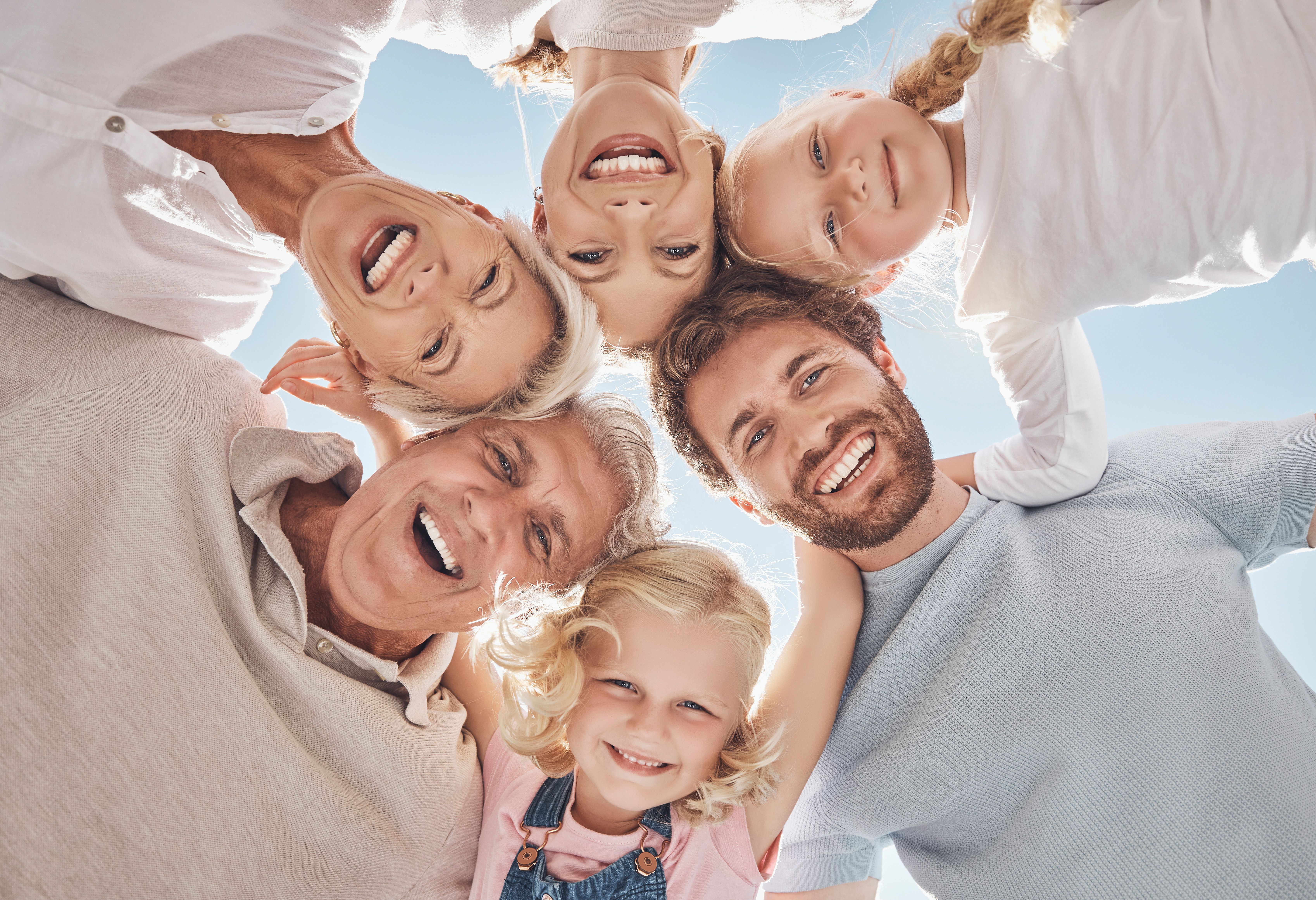 a family smiling at a camera while hugging